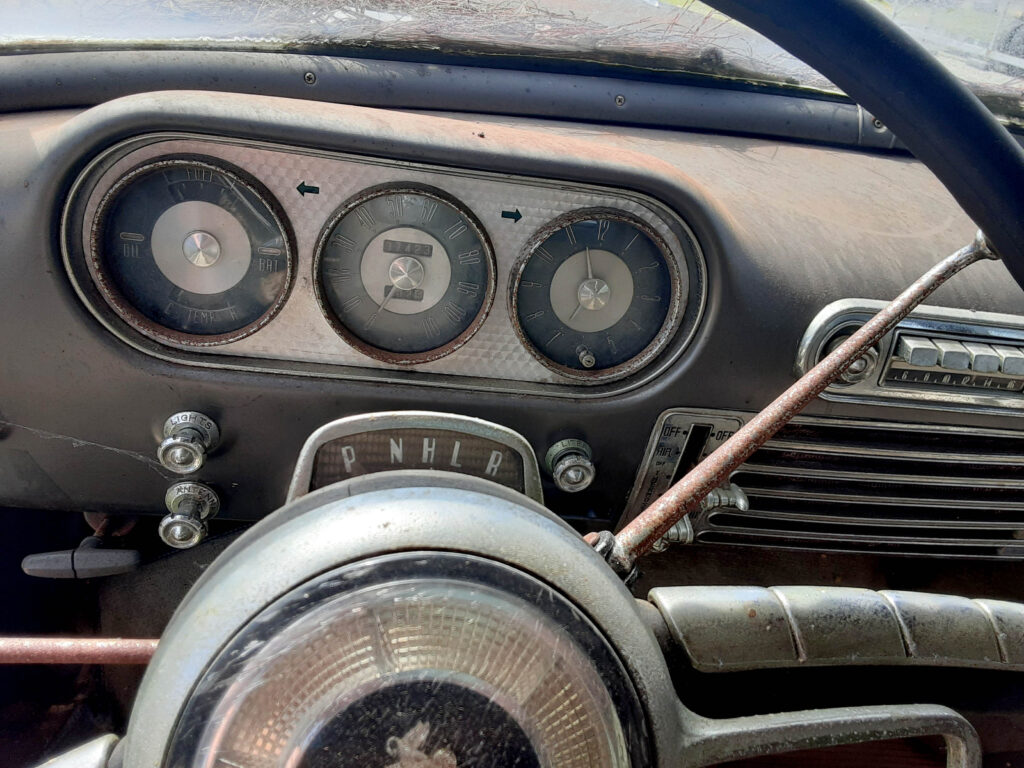1953 Packard Cavalier driver's side, instrument panel, steering wheel, knobs, radio, temperature control.